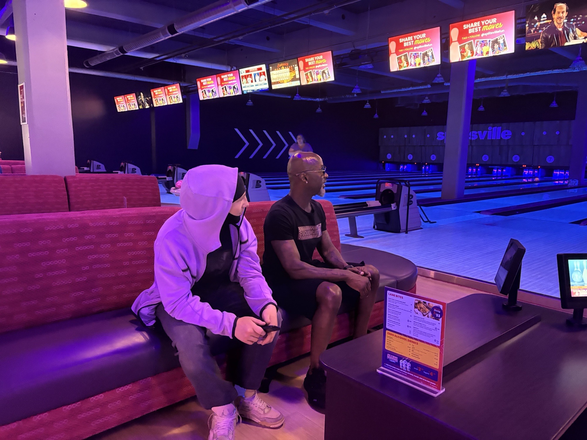 C.O.S.M.O. facilitator in conversation with a youth participant whose face is obscured